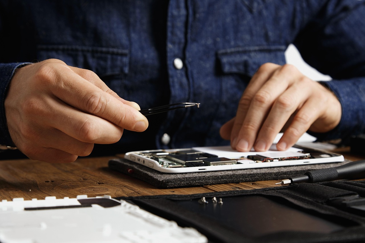 Technician repairing note validator and coin hopper components in a cash handling equipment service workshop